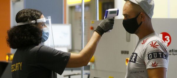 Пассажир в защитной маске проходит температурный контроль в международном аэропорту Борисполь в Киеве Пассажир в защитной маске проходит температурный контроль в международном аэропорту Борисполь в Киеве - Sputnik Lietuva