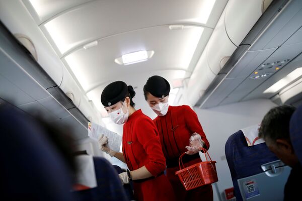 Бортпроводницы в масках и перчатках на борту самолета авиакомпании Сычуань, Китай - Sputnik Lietuva