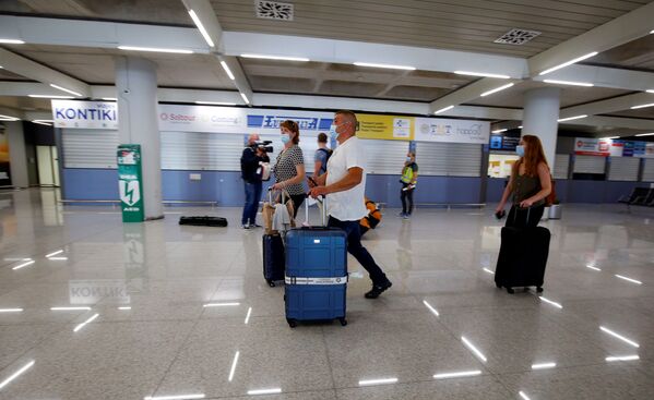 Туристы из Германии в медицинских масках в аэропорту Пальма-де-Майорка в Испании - Sputnik Lietuva
