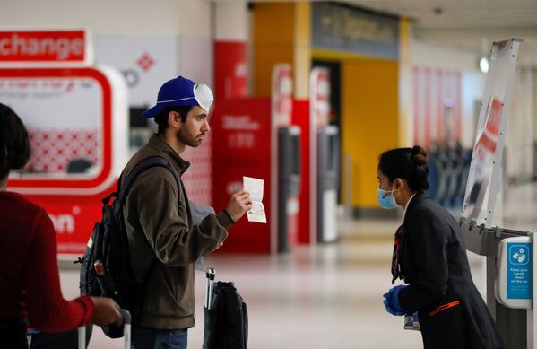 Пассажир предъявляет свой паспорт сотруднику в аэропорту Гатвик, Великобритания - Sputnik Lietuva