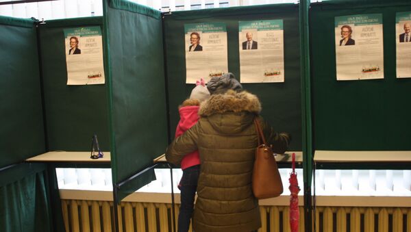 Избирательница заполняет бюллетень в кабинке - Sputnik Литва