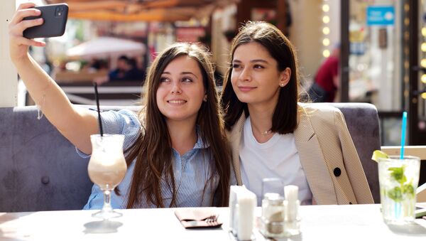 Девушки в летнем кафе на улице Старый Арбат после снятия карантина в Москве - Sputnik Lietuva