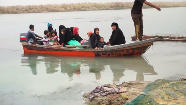 Беженцы из Мосула на лодках переправились через реку Тигр - Sputnik Литва