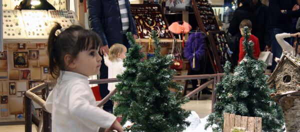 Дети рассматривают рождественские игрушки - Sputnik Литва