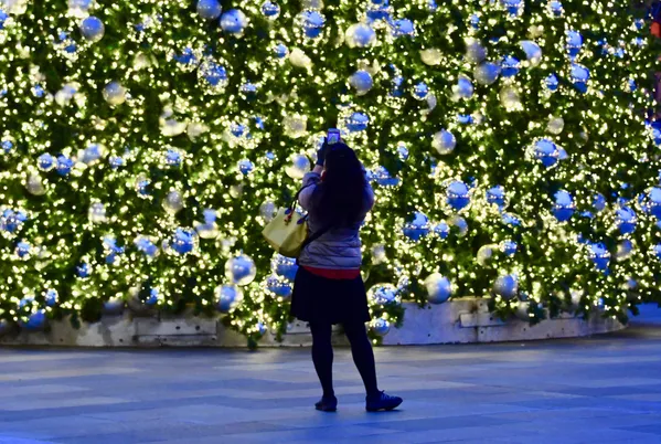 Женщина фотографирует елку в CityCenterDC Женщина фотографирует елку в CityCenterDC - Sputnik Lietuva