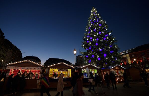 Люди гуляют возле елки на традиционном рождественском рынке - Sputnik Литва
