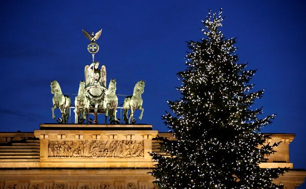 Рождественская елка в гирляндах рядом с Бранденбургскими воротами - Sputnik Литва