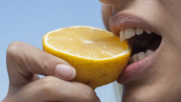 Девушка надкусывает лимон, архивное фото - Sputnik Lietuva