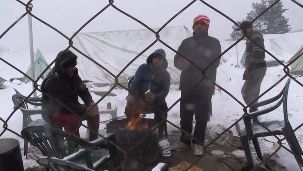 Беженцы грелись у костра в занесенном снегом лагере мигрантов в Салониках - Sputnik Литва