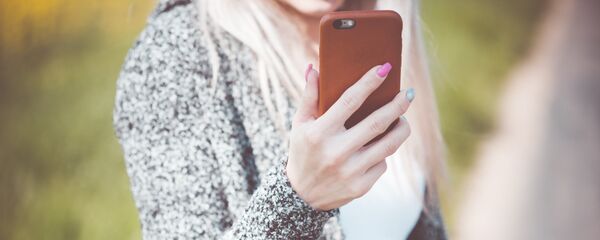 Девушка держит телефон, архивное фото - Sputnik Литва