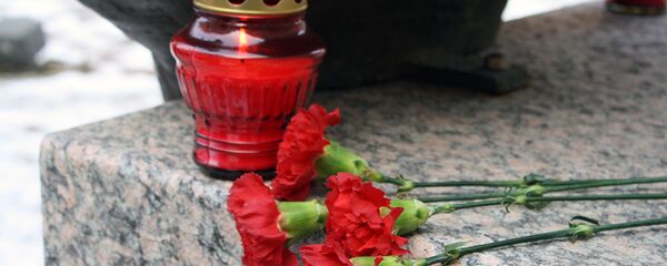 Цветы и свеча на памятнике Цветы и свеча на памятнике - Sputnik Lietuva