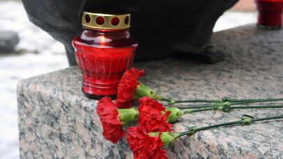 Цветы и свеча на памятнике