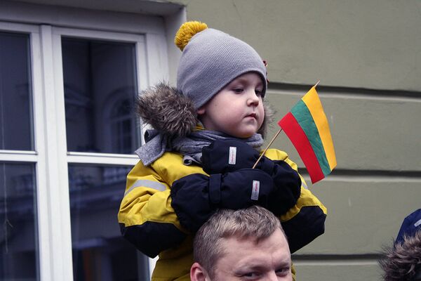Ребенок на плечах отца наблюдает за церемонией поднятия флагов - Sputnik Литва
