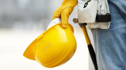 Рабочий держит строительную каску, архивное фото