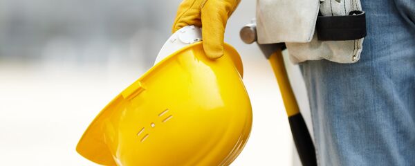 Рабочий держит строительную каску, архивное фото - Sputnik Литва