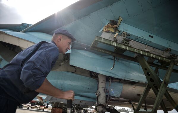 Техник во время обслуживания многофункционального истребителя-бомбардировщика Су-34 на авиабазе Хмеймим в Сирии - Sputnik Литва