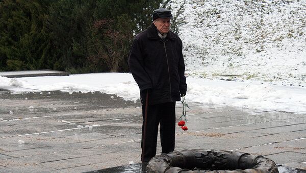 Ветеран с гвоздиками у мемориала советским воинам-освободителям в Вильнюсе - Sputnik Литва
