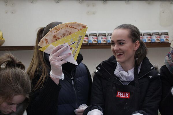 Девушки пекут и продают блины на ярмарке - Sputnik Литва
