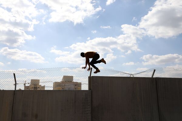 Демонстрант из Палестины перепрыгивает через стену - Sputnik Lietuva