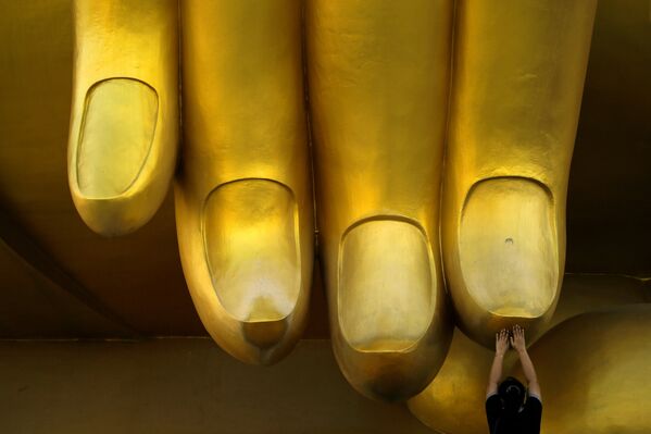 Женщина молится, касаясь пальцами статуи Будды - Sputnik Lietuva