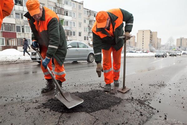 Дорожные работники заделывают дыру в асфальте Дорожные работники заделывают дыру в асфальте - Sputnik Lietuva