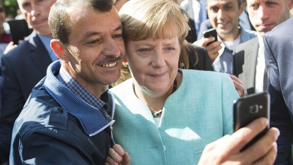 Канцлер Германии Ангела Меркель сфотографировалась с беженцем во время посещения лагеря для мигрантов в Берлине - Sputnik Lietuva