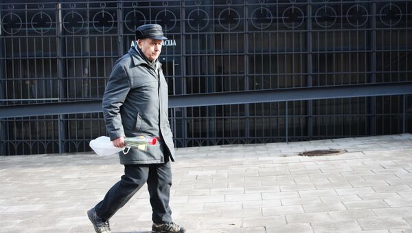 Пенсионер с букетом идет по улице, архивное фото - Sputnik Литва
