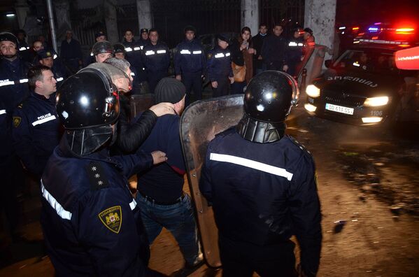 Сотрудники полиции ведут одного из задержанных участников беспорядков в Батуми - Sputnik Литва