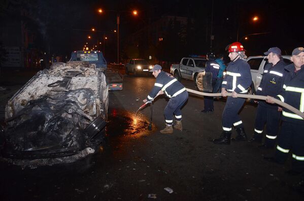 Пожарные тушат один из сожженных в ходе беспорядков в Батуми автомобилей - Sputnik Литва