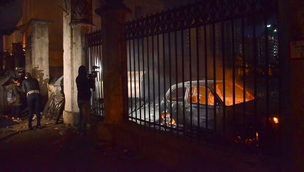 Оператор одного из грузинских телеканалов снимает сожженные в ходе беспорядков в Батуми машины - Sputnik Литва