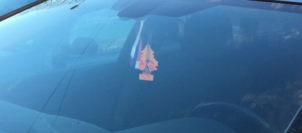 Ленточка цветов российского флага в машине сотрудника МВД Латвии Ленточка цветов российского флага в машине сотрудника МВД Латвии - Sputnik Lietuva