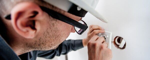 Строитель вставляет розетки Строитель вставляет розетки - Sputnik Lietuva