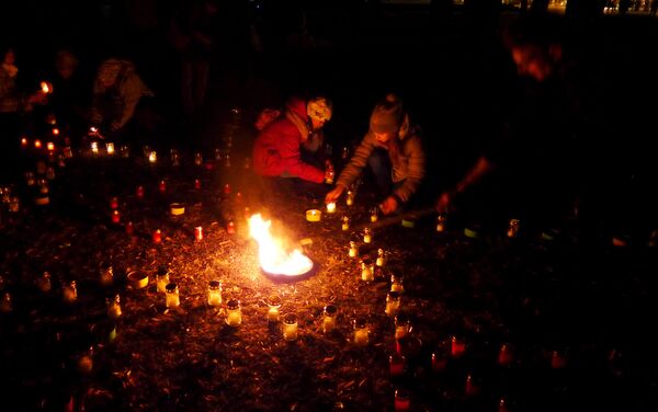 Люди помогают друг другу зажечь многочисленные свечи - Sputnik Литва
