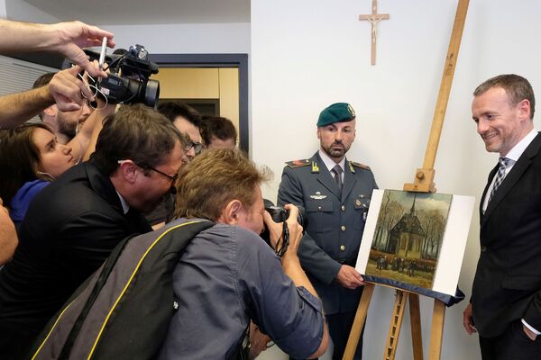 Журналисты фотографируют спасенную картину Выход из протестантской церкви в Нюэнене Журналисты фотографируют спасенную картину Выход из протестантской церкви в Нюэнене - Sputnik Литва
