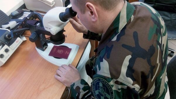 Пограничник осматривает литовский паспорт - Sputnik Литва