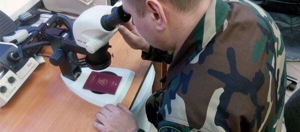 Пограничник осматривает литовский паспорт Пограничник осматривает литовский паспорт - Sputnik Литва