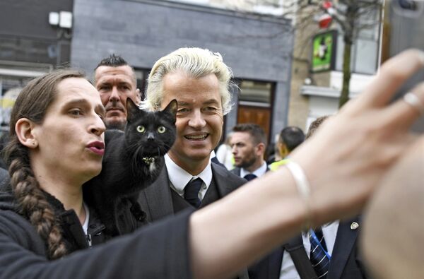 Голландский ультраправый политик Герт Вилдерс позирует с женщиной и кошкой - Sputnik Литва