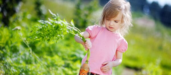 Девочка на грядке с морковкой Девочка на грядке с морковкой - Sputnik Lietuva