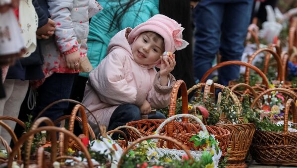 Девочка ждет возле церкви благословения пасхальных куличей и яиц перед богослужением в Пустомытах, Украина - Sputnik Lietuva