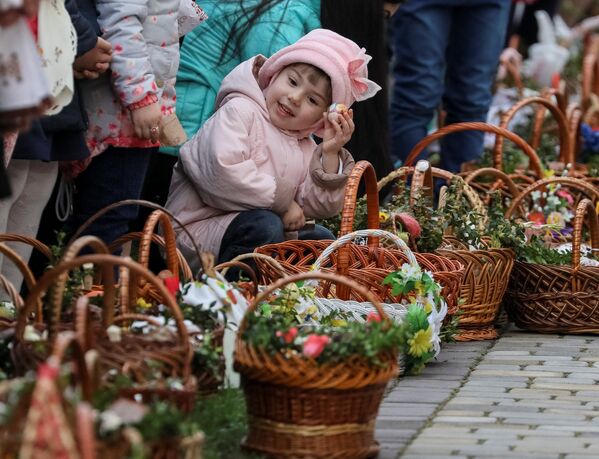 Девочка ждет возле церкви благословения пасхальных куличей и яиц перед богослужением в Пустомытах, Украина - Sputnik Литва