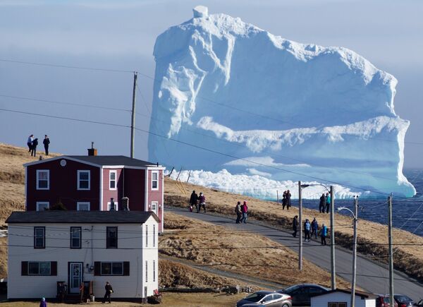 Люди рассматривают первый айсберг в новом сезоне, который плывет через южный берег Ньюфаундленда, Канада - Sputnik Lietuva