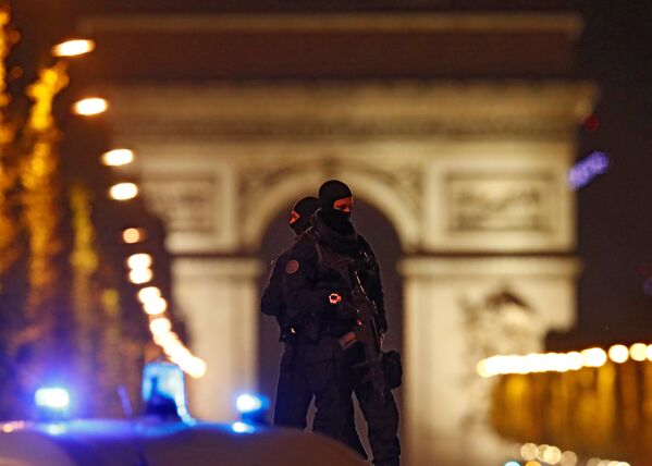 Полицейские в масках стоят на своем автомобиле на проспекте Елисейские Поля после инцидента в Париже - Sputnik Lietuva