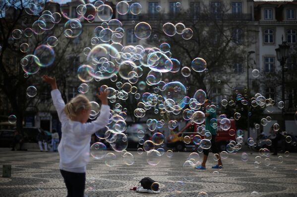 Уличный художник выступает с мыльными пузырями на площади Россио в центре Лиссабона - Sputnik Lietuva