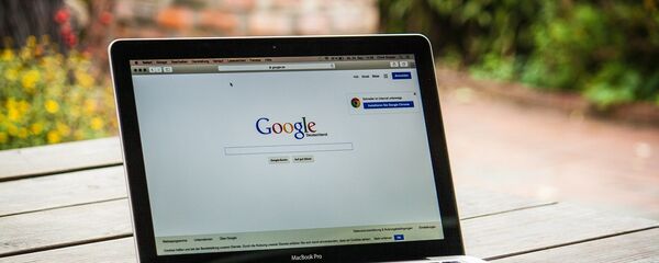 Ноутбук на столе с интернет-страницей Google - Sputnik Литва