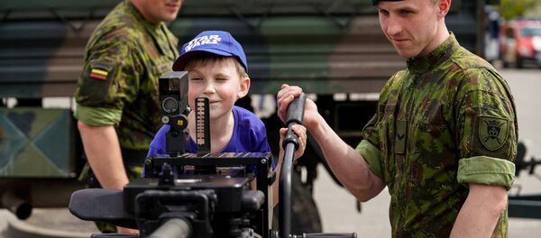 Солдат литовской армии показывает ребенку крупнокалиберный пулемет - Sputnik Литва