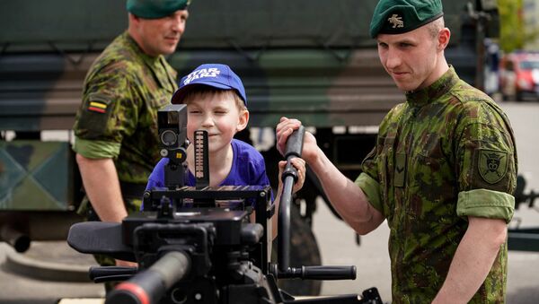 Солдат литовской армии показывает ребенку крупнокалиберный пулемет - Sputnik Литва