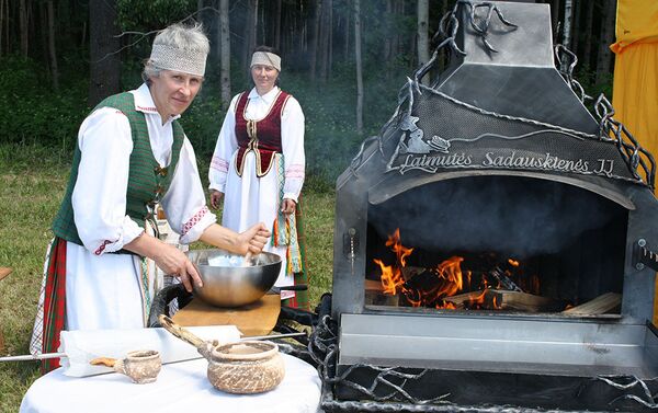 Женщины в литовских национальных костюмах готовятся к выпечке шакотиса - Sputnik Литва