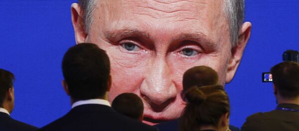 Владимир Путин на экране перед аудиторией - Sputnik Литва