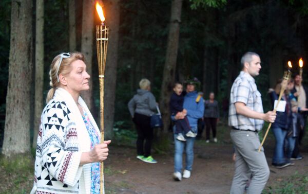 Факелы, зажженные от ритуального костра, в руках участников праздника - Sputnik Литва