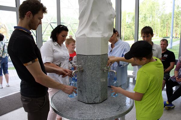 Заряженной водой наполняют пластиковые бутылки внутри беседки-часовни Заряженной водой наполняют пластиковые бутылки внутри беседки-часовни - Sputnik Литва
